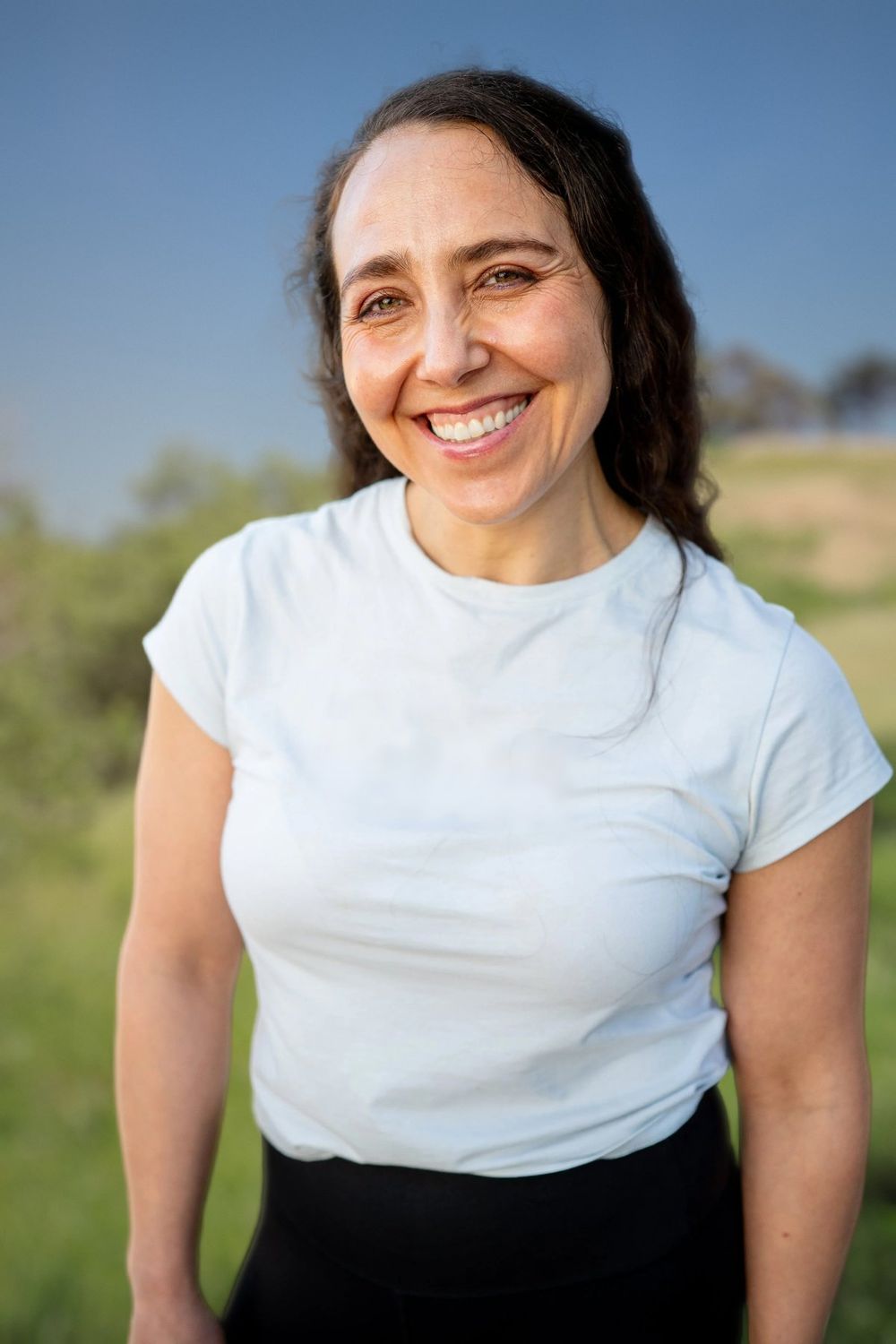 Renée Asteria Peñaloza, NASM-certified personal trainer in San Francisco, smiling outdoors in Glen Canyon Park