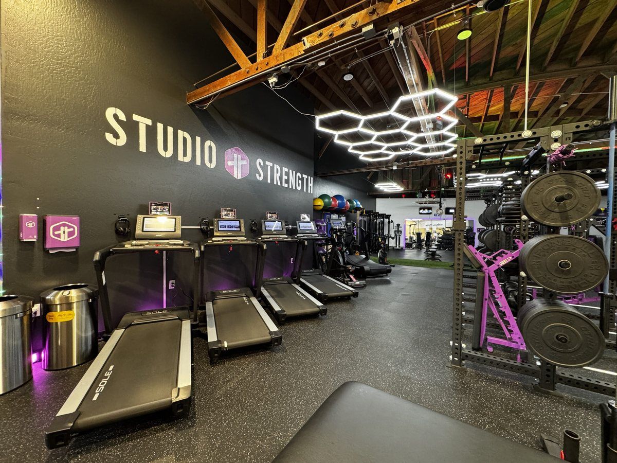 Gym floor at Trainability Potrero Hill with treadmills, a plate-loaded rack and hexagon ceiling lights under a Studio Strength wall sign
